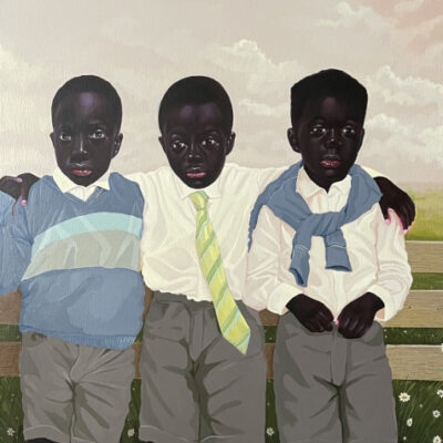 three school boys against a school fence