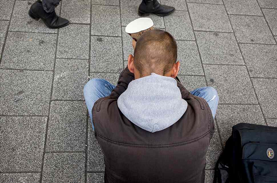 man sitting on the street begging
